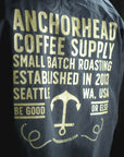 Navy jacket with gold text and logo for Anchorhead Coffee Supply on a black background