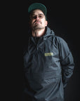 Man wearing a dark jacket with a brand logo on a black background