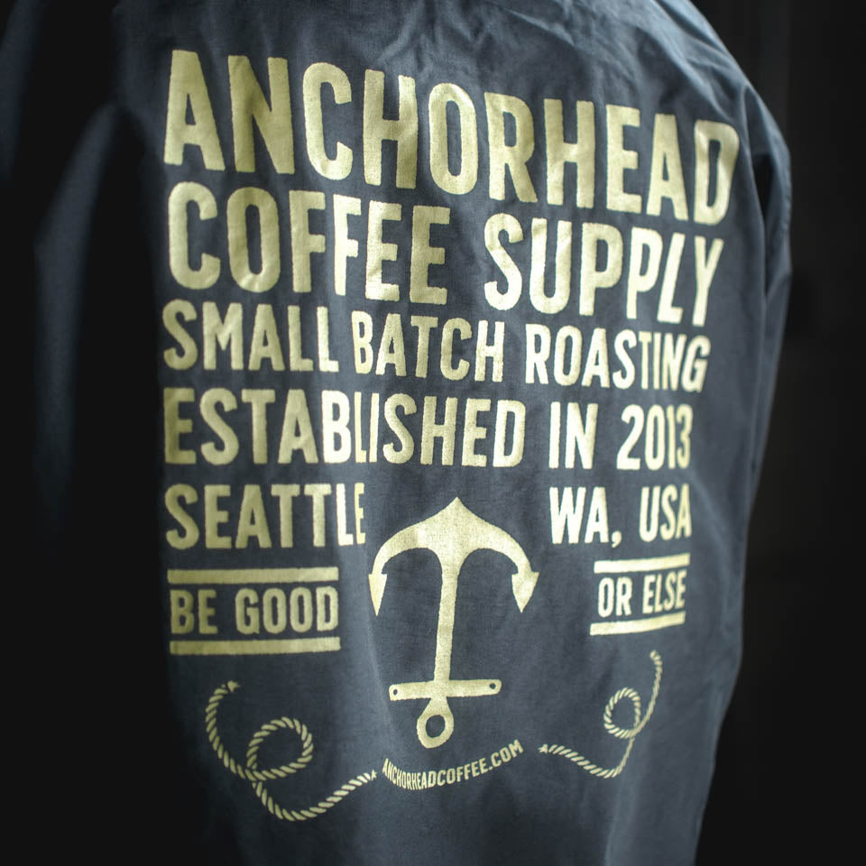 Navy jacket with gold text and logo for Anchorhead Coffee Supply on a black background