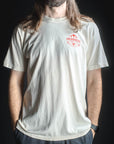 Person wearing a light gray t-shirt with a red logo on a black background
