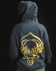 Person wearing a dark hoodie with a gold emblem on the back against a black background