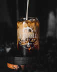 A dark-colored glass can with 'Anchorhead Coffee Co' printed on it, filled with a beverage, presented on a dark background.