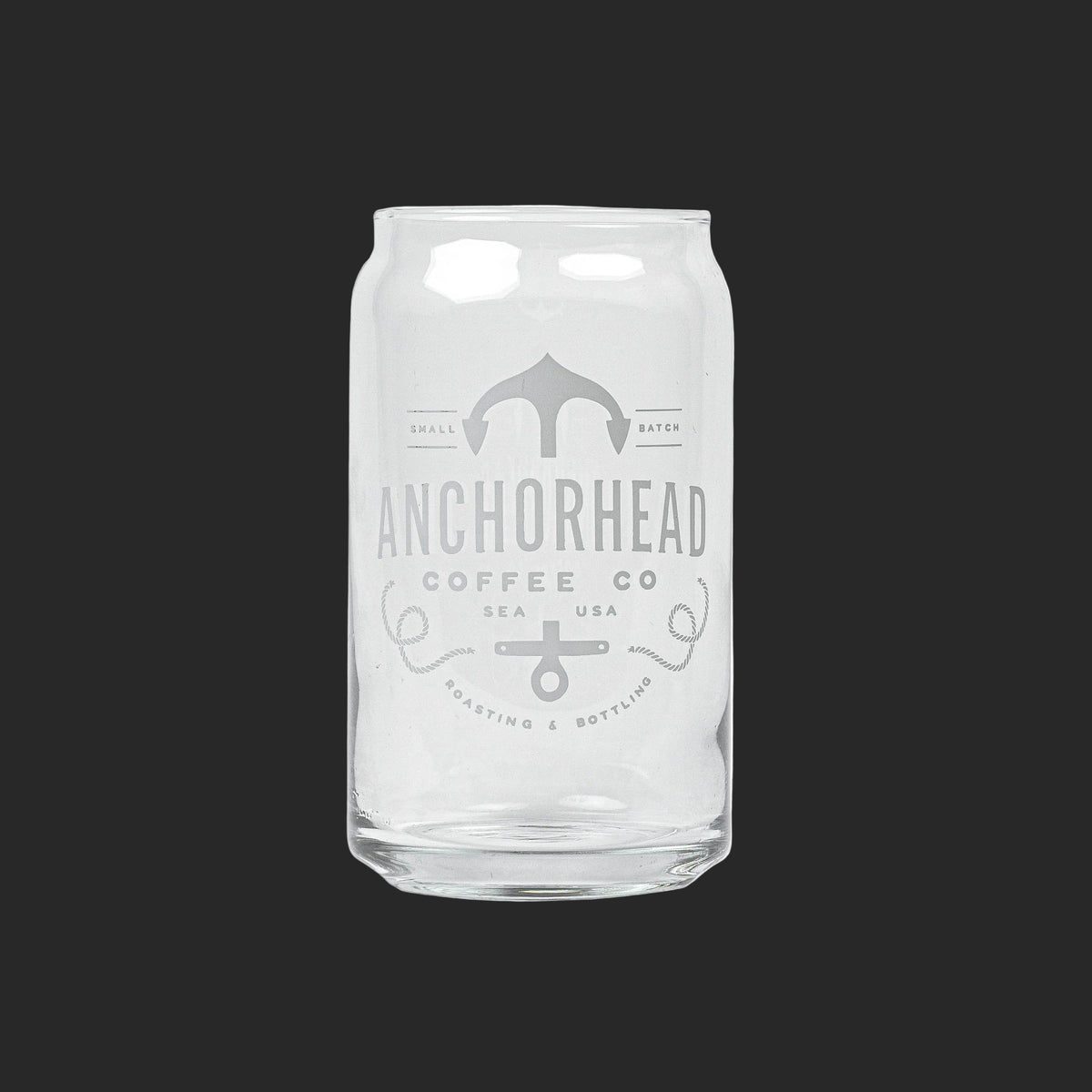 Clear glass resembling a soda can with "Anchorhead Coffee Co" and an anchor logo printed in white. Minimalistic design on a dark gray background.